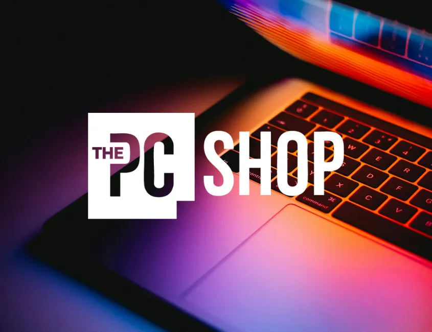 The PC Shop logo over a glowing laptop keyboard